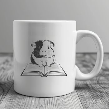A cute guinea pig holding a book, suitable for use as clip art in digital designs.