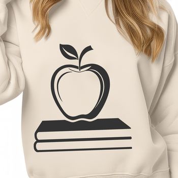 A teacher's desk with an open book featuring the apple logo on the cover, suitable for educational settings.