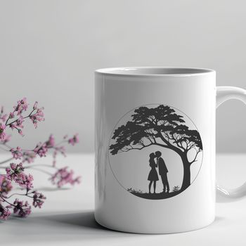 A pair embracing under the branches of a large tree.