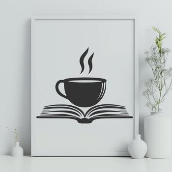 A simple white ceramic coffee cup on a wooden table next to an open book.