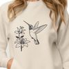 A colorful hummingbird in mid-air, surrounded by floral elements.