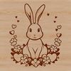 A cute rabbit sitting on a grassy surface surrounded by heart symbols.