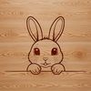 A cartoon-style illustration of a rabbit's head peeking out from behind a floral wreath.