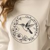 Colorful Hummingbird Vector Graphics A colorful hummingbird perched on a floral branch, depicted as a vector graphic.