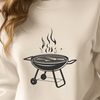 Grilled foods on a barbecue set with utensils and condiments.