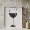 A stylized illustration of a wine glass filled with red wine on a table or countertop.