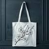Sakura flower with soft pink undertones A delicate white cherry blossom with pink undertones on a green stem.