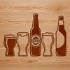 Beer Glass on Wooden Table A refillable glass filled with beer on a wooden table.