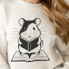 Cute Hamster Reading a Book A cartoon hamster sitting on top of an open book with a curious expression.