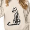 A portrait of a wild ocelot sitting on its haunches.