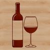 A glass bottle of red wine on a wooden table.